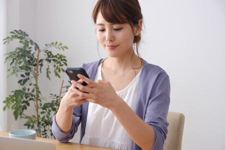 スマートフォンから問い合わせをする女性