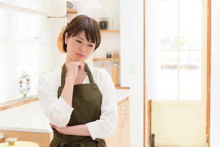 料理の献立が思い付かず困っている女性